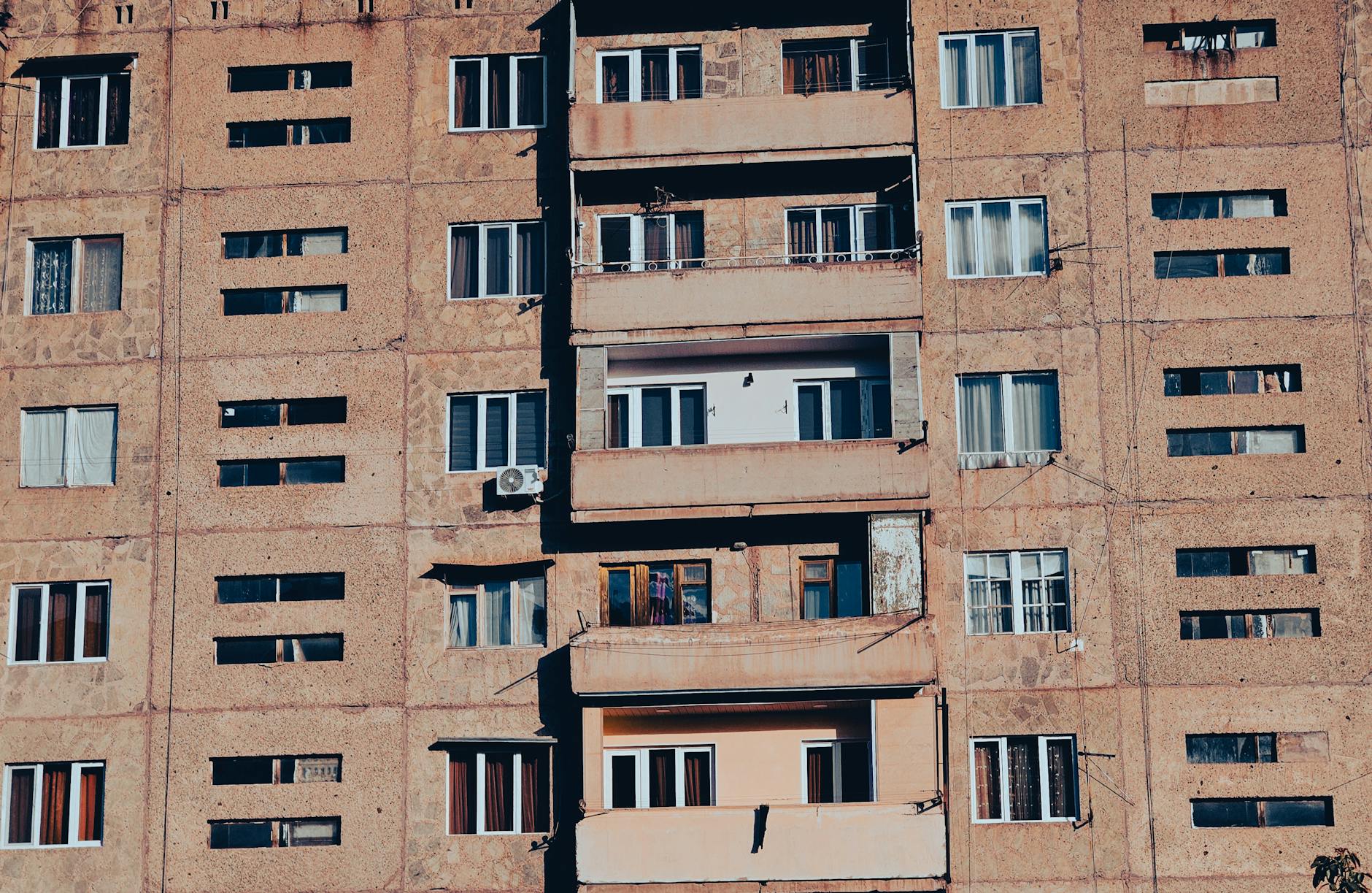 Fasada miejskiej kamienicy z balkonami i oknami z połowy XX wieku